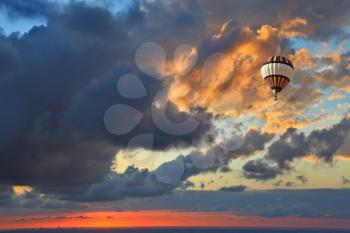 The magnificent sunset over the Adriatic Sea. Huge air balloon flying over the sea