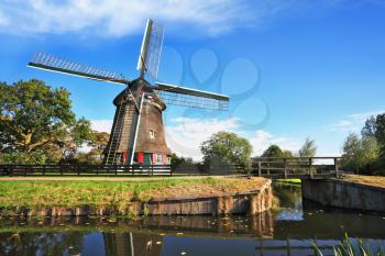  Verdant grove, quiet stream and a symbol of the country - Windmills. Rural landscape in the Netherlands
