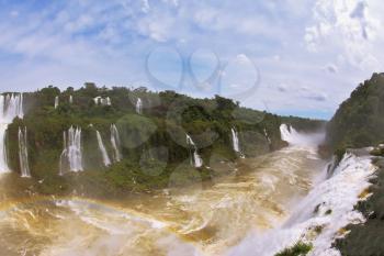Raging and roaring water in the Brazilian side of the Iguazu Falls.  Turbid yellow-brown waves flow down
