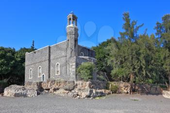 One of the oldest churches in the Sea of Galilee. Stone wall of gray stone on a smooth slope to the lake water