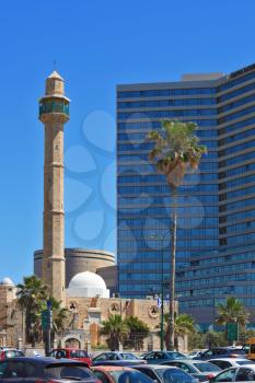 TEL AVIV, ISRAEL - MAY 2, 2014:  Arab mosque and minaret on the background of high-rise hotel. Spring Tel Aviv promenade