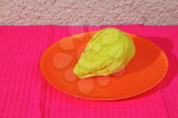 Jewish ritual fruit - yellow etrog on orange plate and crimson cloth