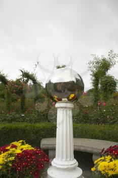  A mirror sphere on a plaster pedestal and the two tourists reflected in it