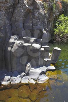 Canyon with cut basalt walls and a drying up stream