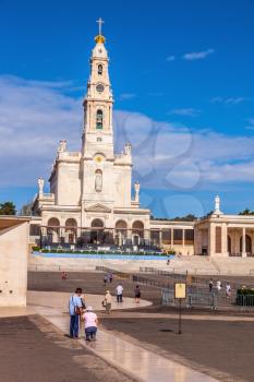 FATIMA, PORTUGAL - SEPTEMBER 9, 2011: Religious woman kneeling on a specially built track. The area in front of the Catholic cathedral with tourists and believers