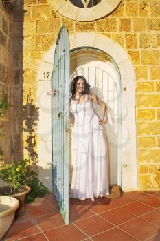  The beautiful bride in a white dress on a background of ancient walls of ancient city   