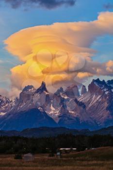 Fantastic sunset in the national park Torres del Paine, Chile. The clouds are illuminated by the sun on the rocks Los Kuernos