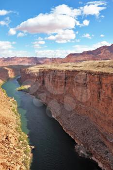 Majestic landscape. Green water of the river Colorado in abrupt coast of desert from red sandstone
