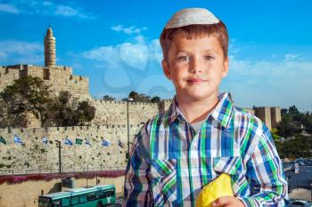 Charming seven year old boy in white festive skullcap with etrog. Sukkot in Jerusalem