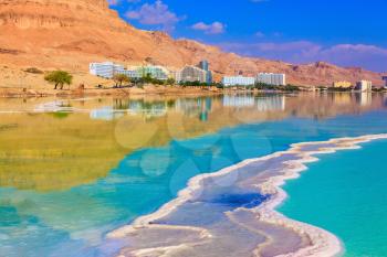 Emerald water of the Dead Sea. Fused salt made on the surface of the water