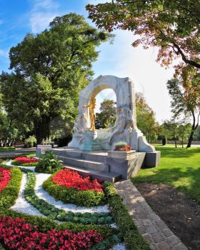 Elegant marble arch frames the bronze statue of Johann Strauss. Wonderful park in the center of Vienna