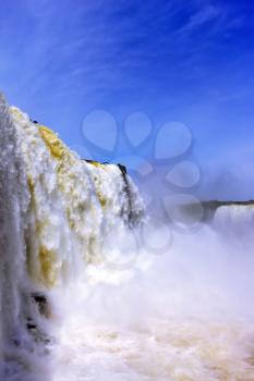  White whipped foam of water and a thin mist over the water. The most high-water waterfall in the world - Iguazu