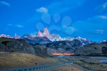 Amazing Patagonia in February. The valley of town of El Chalten.  The white top of Fitzroy rocks and village of El Chalten at dusk 