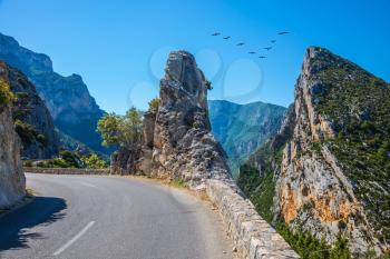 The picturesque and dangerous hairpin bend on a mountain road. The migrating cranes over road. The largest alpine canyon Verdon, Provence, France