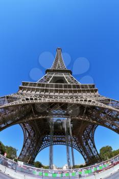 The picture was taken by lens Fisheye. The most famous in the world - the Eiffel Tower in the background of bright blue sky. At the foot of the tower - a park and a large pond