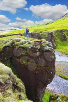 Fantastic country Iceland. The enthusiastic tourist on a rock canyon  Fjadrargljufur