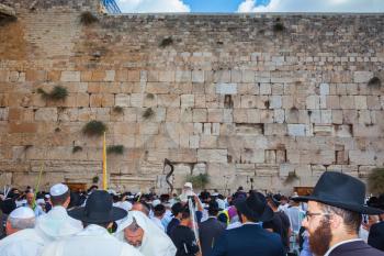 JERUSALEM, ISRAEL - OCTOBER 12, 2014:  The area in front of Western Wall of Temple filled with people.  Morning autumn Sukkot, Blessing of the Kohanim. The Jews of ritual clothes - tallit hold four ri
