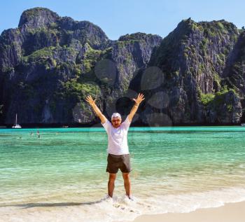 Cheerful elderly man standing in sea water at the beach in Thailand