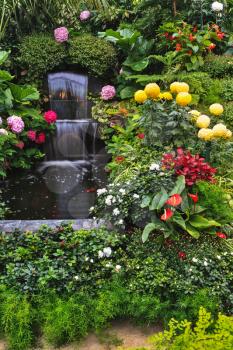  Butchart Garden Park on Vancouver Island, Canada. Luxury three-stage Fountain Mirror stream among the flowers