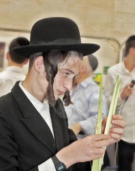 BNEI- BRAK, ISRAEL - SEPTEMBER 17, 2013: Traditional market before the holiday of Sukkot. Religious Jews in black hats and skullcap of carefully selected ritual plants