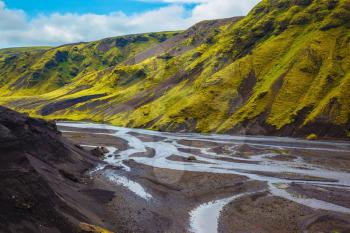 Canyon Pakgil in Iceland. Picturesque basalt hills covered with green grass and moss-polar. Streams from melting glaciers flowing down the canyon
