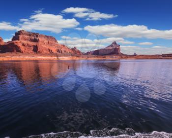 Scenic huge artificial water basin of the Colorado River, USA. Lake Powell is surrounded by magnificent sandstone hills. A boat trip on a sunny day