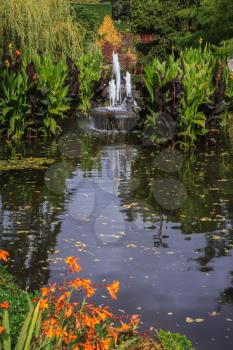 Small fountain in quiet pond. Autumn park Butchart Gardens on Vancouver Island, Canada