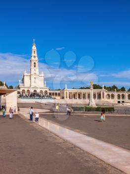 FATIMA, PORTUGAL - SEPTEMBER 9, 2011: The area in front of the Catholic cathedral with tourists and believers. Religious woman kneeling on specially built track