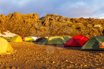 Tents tourists, mountains and glaciers covered with warm sunlight. Fairy dawn National Park Landmannalaugar, Iceland