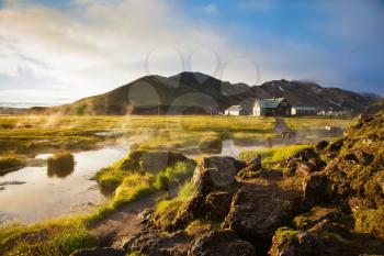 Sunrise Park Landmannalaugar. Above the source of thermal water steam rises. White nights in Iceland