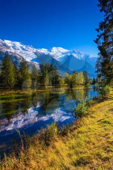  The lake reflected the snow-capped Alps and evergreen spruce. Early autumn in Chamonix, Haute-Savoie. France