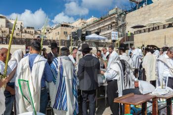 JERUSALEM, ISRAEL - OCTOBER 12, 2014:  Morning autumn Sukkot. Crowd of Jewish worshipers in white wearing prayer shawls. The area of Western Wall of  Temple filled with people