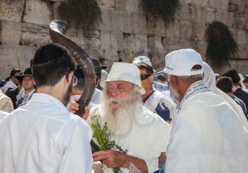JERUSALEM, ISRAEL - OCTOBER 12, 2014: Morning autumn Sukkot. The area in front of Western Wall of  Temple filled with people. Elderly religious Jew with a Shofar