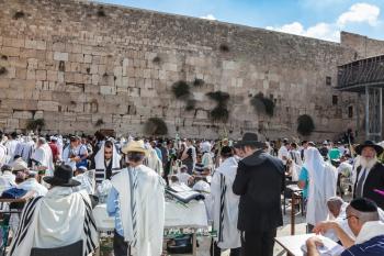 JERUSALEM, ISRAEL - OCTOBER 12, 2014:  Hhuge crowd of faithful Jews wearing white prayer talit and black long-skirted coats. Morning autumn Sukkot
