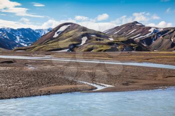  Summer flood of meltwater blocks the way to tourist camping. The picturesque valley in national park Landmannalaugar, Iceland