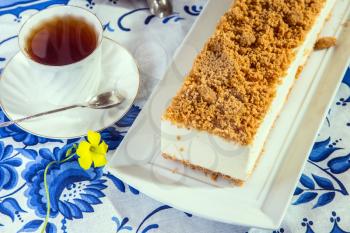  Gorgeous white cheesecake, sprinkled with sweet crumbs. Professional bakery. The background is  porcelain cup with hot tea 