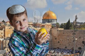 Cute seven year old boy in white skullcap with the etrog. Sukkot at the Western Wall of Temple in Jerusalem