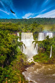 The fantastic Iguazu Falls in South America, on the border of three countries: Brazil, Argentina and Paraguay. Concept of active and extreme tourism