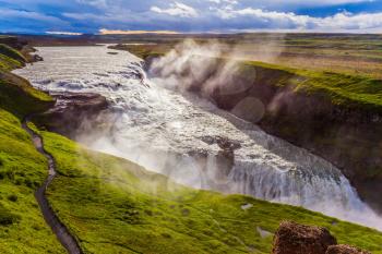 Gullfoss - Golden Waterfall in Iceland. Falls on the Hvitau River. Cloudy and foggy July day. The concept of extreme and phototourism