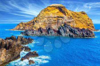 The concept of ecological and exotic tourism. Calm bay with azure water. Rocks and stones off the shores of the volcanic island of Madeira