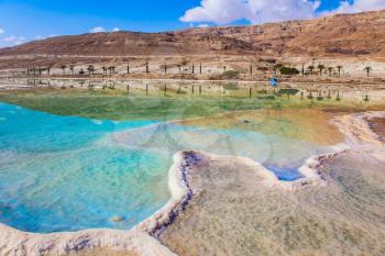 Summer, Israel. Very salty water in the Dead Sea glows with turquoise light. The concept of ecological and medical tourism