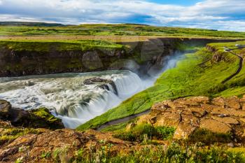 Huge masses of water crash into a narrow gorge. The most picturesque waterfall in Iceland - Gullfoss on the Hvitau River. The concept of extreme and phototourism