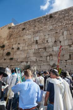 JERUSALEM, ISRAEL - OCTOBER 12, 2014:  Huge crowd of faithful Jews wearing white prayer talit and black long-skirted coats. Morning autumn Sukkot
