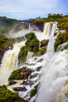  World of falling water. The waterfalls Iguazu. Picturesque basaltic rocks form the famous waterfalls. The concept of active and exotic tourism