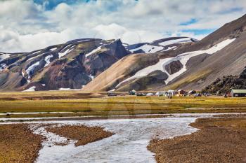The picturesque valley in the national park Landmannalaugar, Iceland. Summer flood of meltwater flooded the road to tourist camping