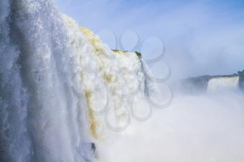 The world-famous Iguazu Falls. Water fog over Iguazu Falls on the border of Brazil, Argentina and Paraguay. Concept of active and extreme tourism