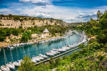Calanque National Park - small fjords between Marseille and Cassis. Picturesque small bay - Calanques with turquoise water. White sailboats moored in rows near the shore