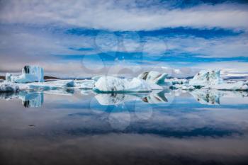 Ice magnificence. Floating ice and clouds are reflected in smooth mirror water of the Ice lagoon. Iceland