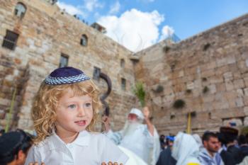 Jerusalem, Western Wall of the Temple. Autumn Jewish holiday Sukkot. Handsome little boy with blond side curls and blue eyes, in skullcap