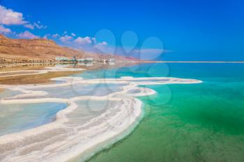 Very salty water glows with turquoise light. The concept of ecological and medical tourism. The evaporated salt has developed into fantastic patterns